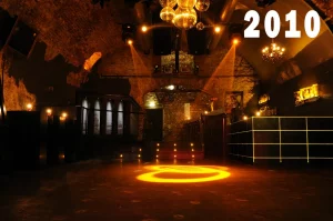 Innenansicht des Eiskeller Clubs im Jahr 2010 mit warm beleuchtetem Ziegelgewölbe, Spiegelkugeln und Lichtprojektion auf der Tanzfläche.